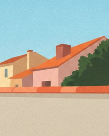 Les toits de tuiles orange et la maison rose, sous un grand ciel bleu, derrière le muret