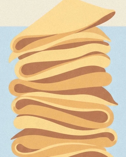 Le sommet d’une pile de crêpes dorées aux plis souples sur fond bleu pâle