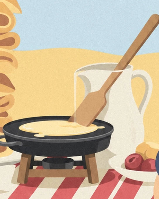 La crêpière noire, sa spatule en bois et le pichet blanc sur la nappe rayée
