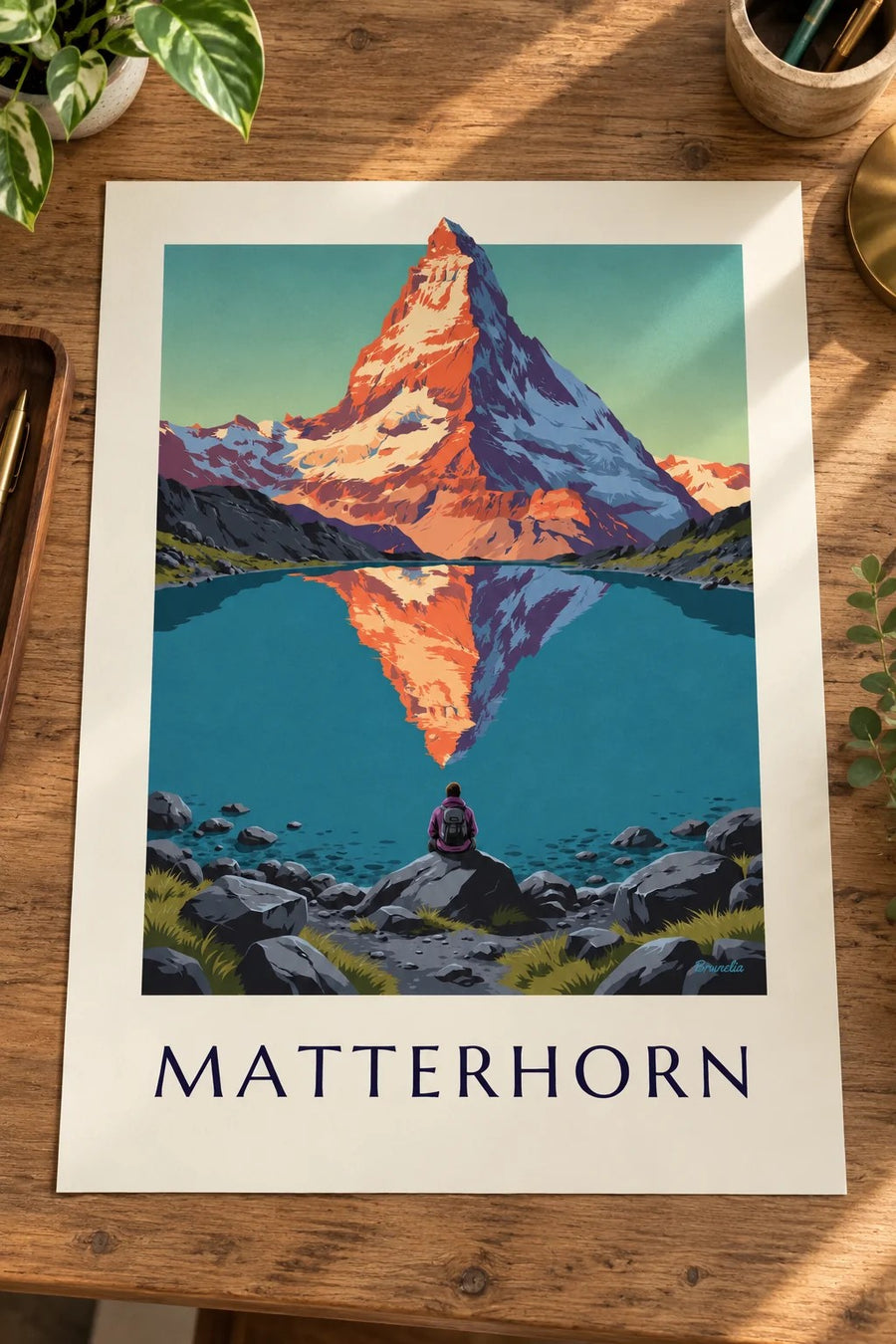 Affisch med Matterhorn i solnedgången speglat i en alpsjö: liggande på ett bord