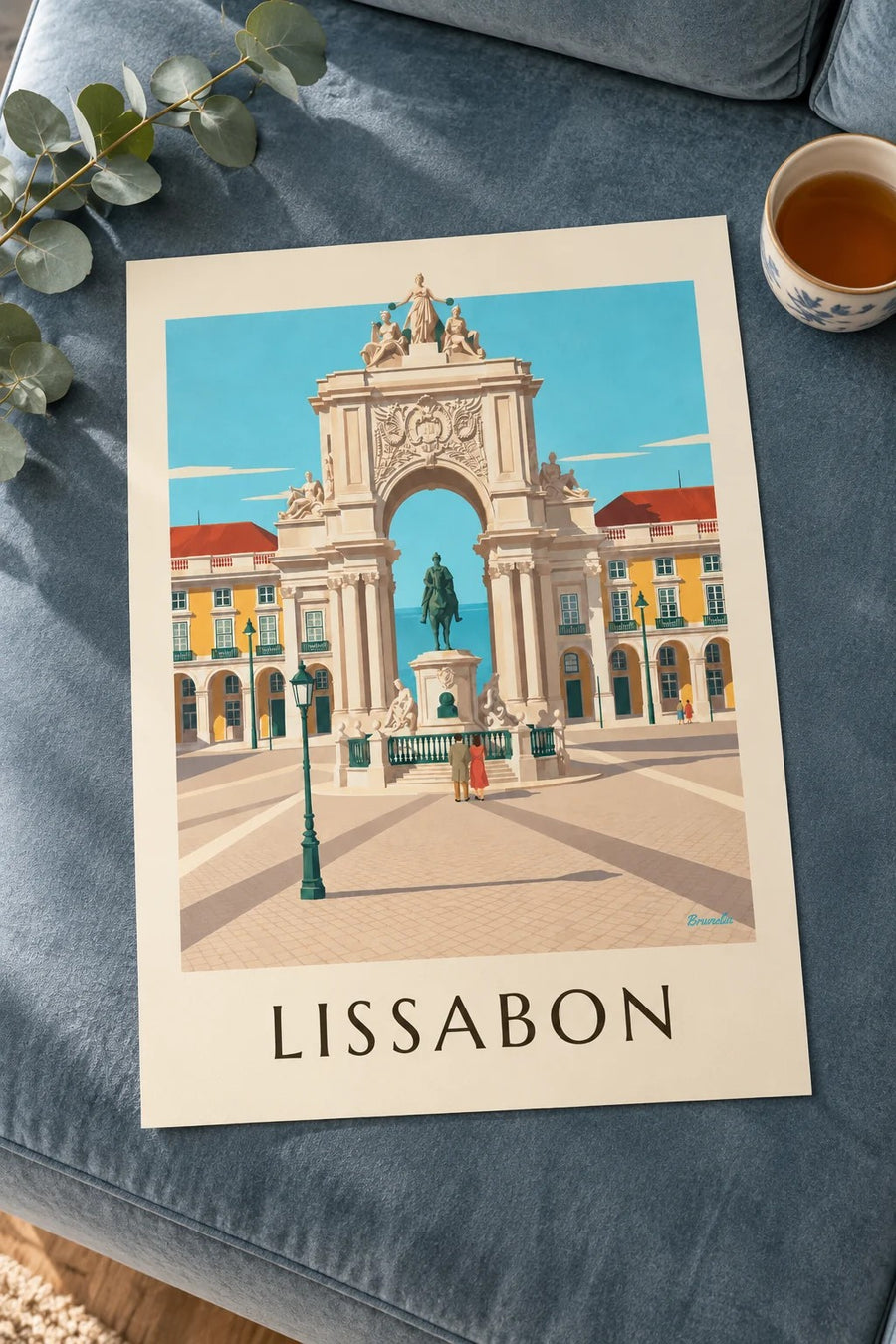 Affisch med Praça do Comércio och Rua Augustas triumfbåge i Lissabon: liggande på ett bord