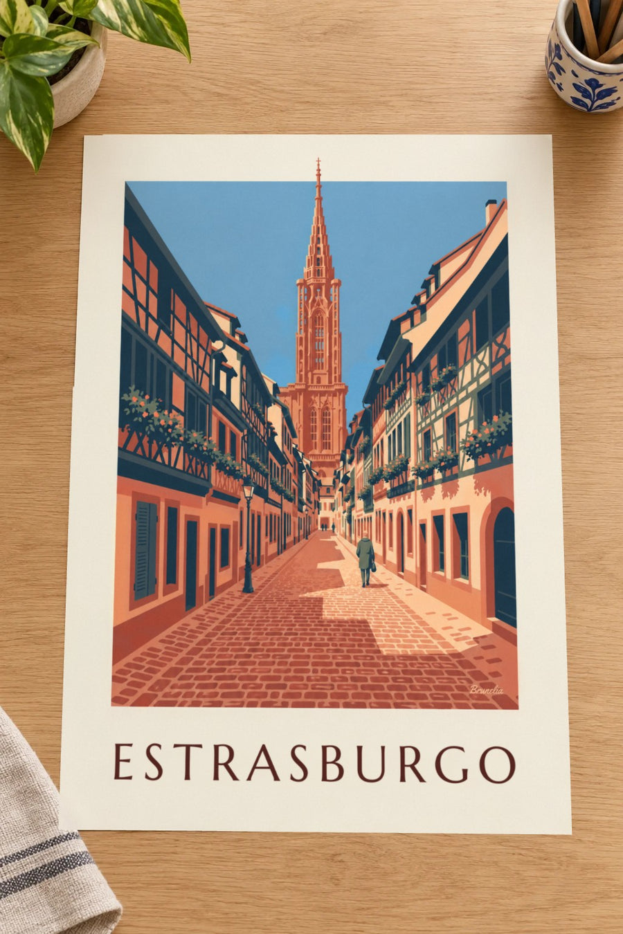 Cartaz de uma rua empedrada e da catedral do centro histórico de Estrasburgo: pousado numa mesa