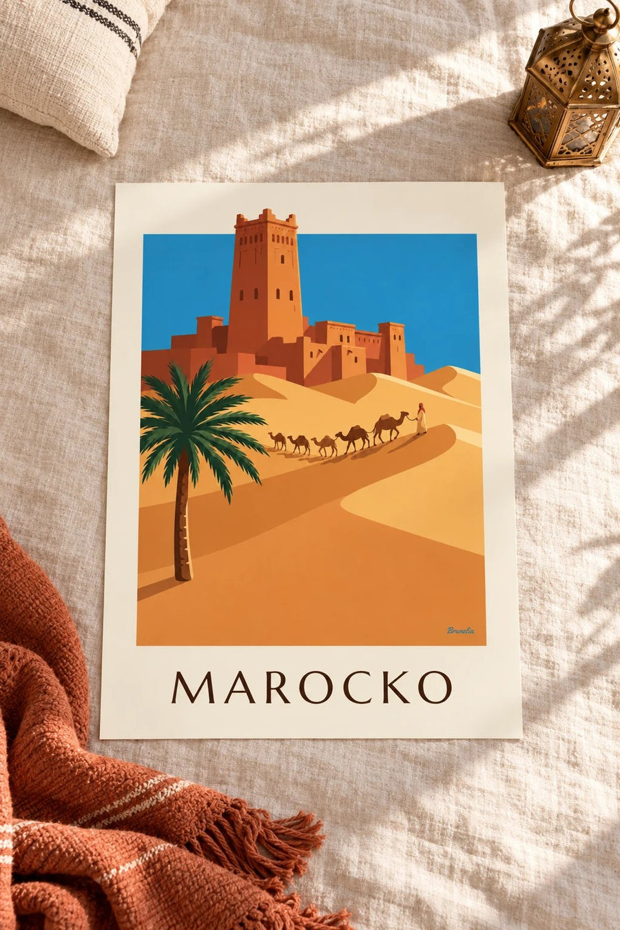 Affisch med kasbah och kamelkaravan i den marockanska öknen: liggande på ett bord