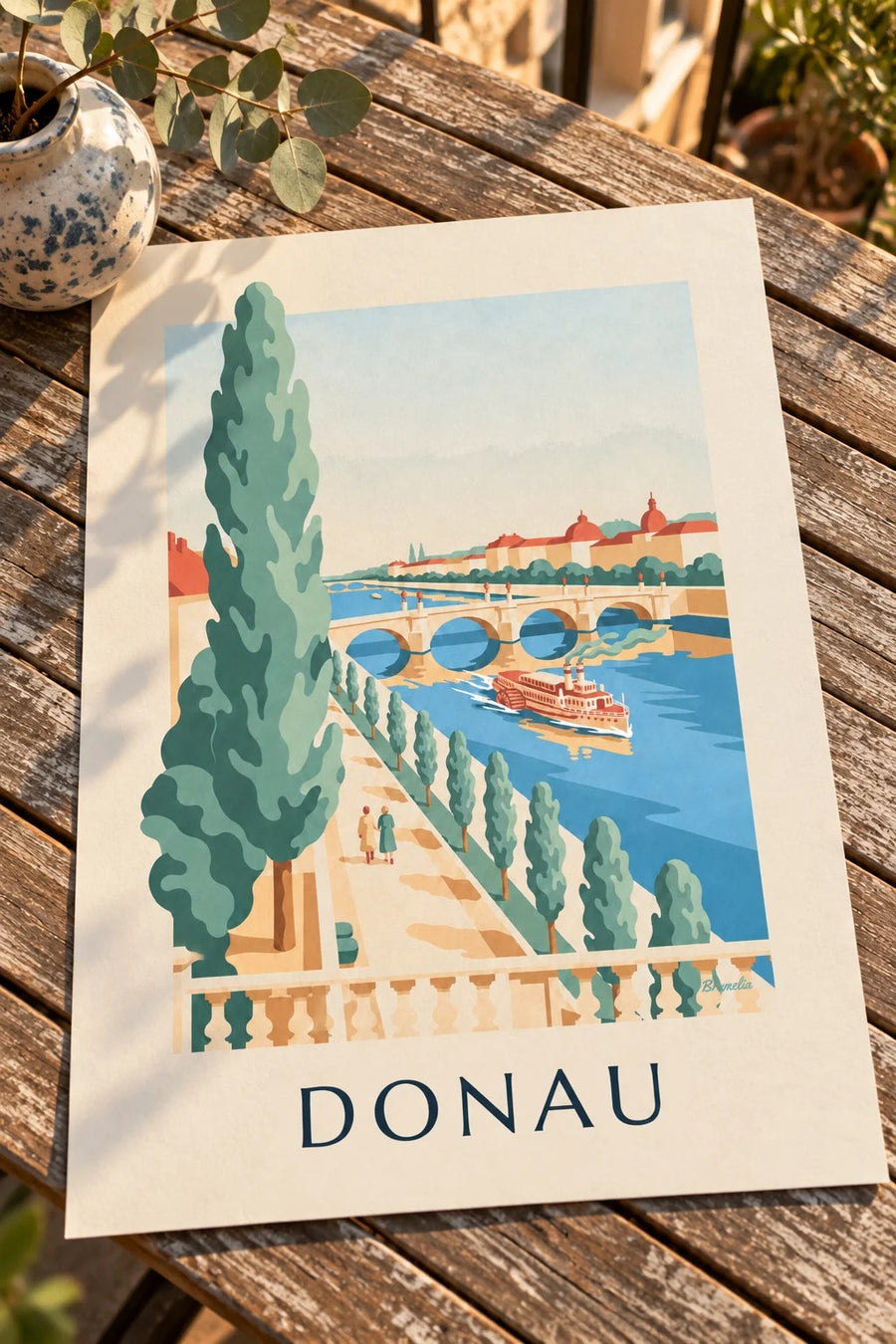 Affisch med promenad längs Donau och hjulångare: liggande på ett bord