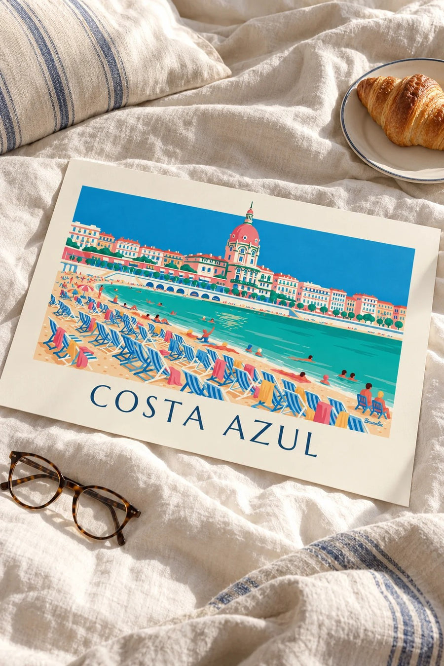 Poster de banhistas e espreguiçadeiras sob a Promenade des Anglais, em Nice: pousado numa mesa