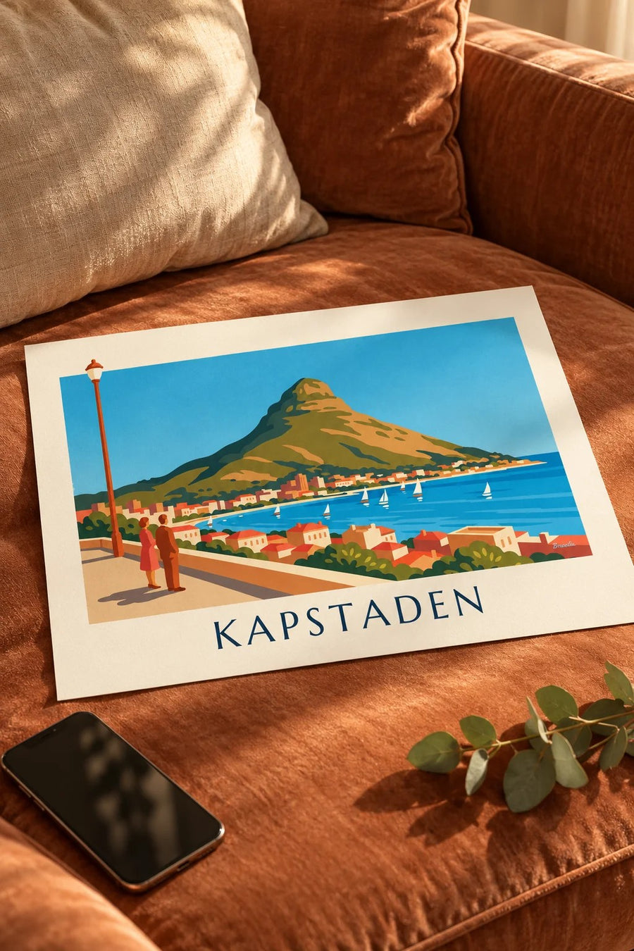 Poster med Kapstaden, Lion's Head och bukten med segelbåtar från strandpromenaden: liggande på ett bord