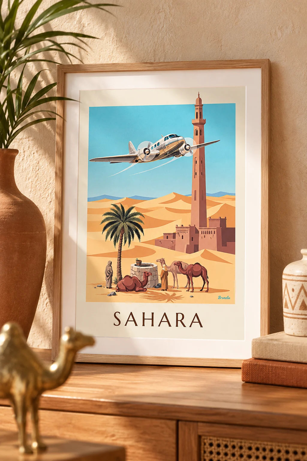 Escritório: Cartaz de avião trimotor a sobrevoar um oásis e as dunas do Sara na parede